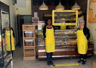 Interior of Uncle John's Bakery, showing staff in protective clothes and protected counter space