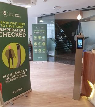 COVID-19 safety advice and temperature checking station at reception of Heineken London office building