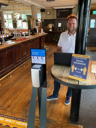 Social distancing information and hand sanitiser next to bar at Fullers pub